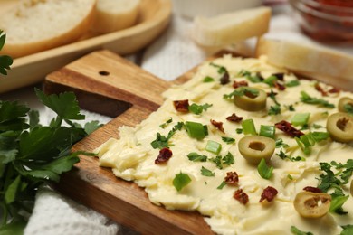 Photo of Fresh butter board with cut olives, onion and sun-dried tomatoes on table, closeup