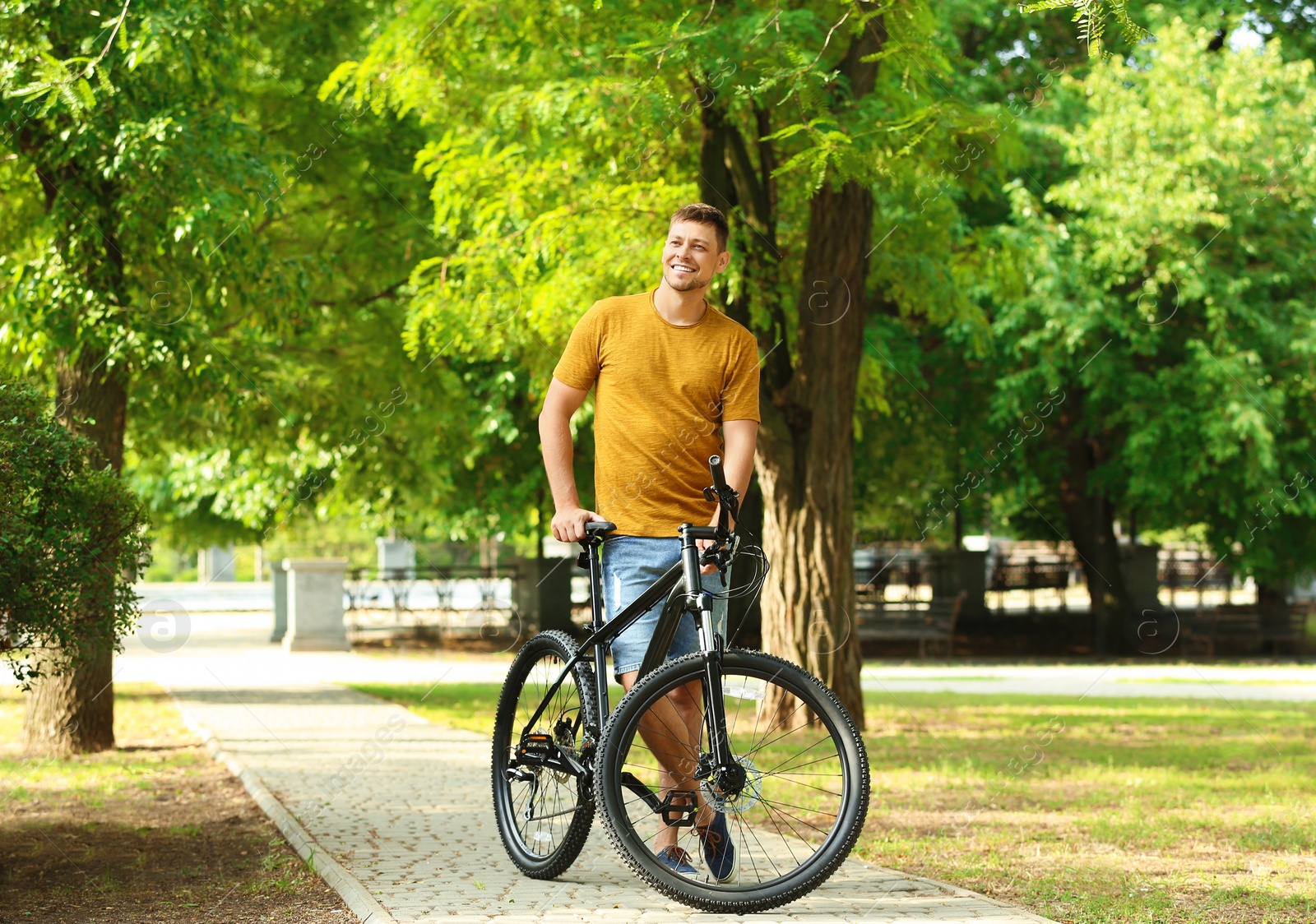 Photo of Handsome man with modern bicycle in park