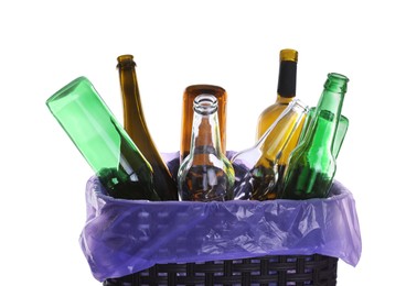 Photo of Trash bin full of glass bottles on white background, closeup. Recycling rubbish