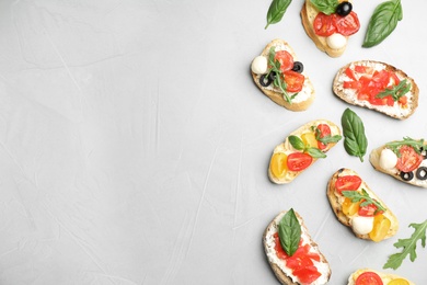 Photo of Delicious tomato bruschettas on light grey background, flat lay. Space for text