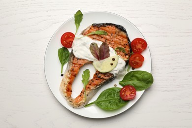 Tasty salmon steak served on white wooden table, top view