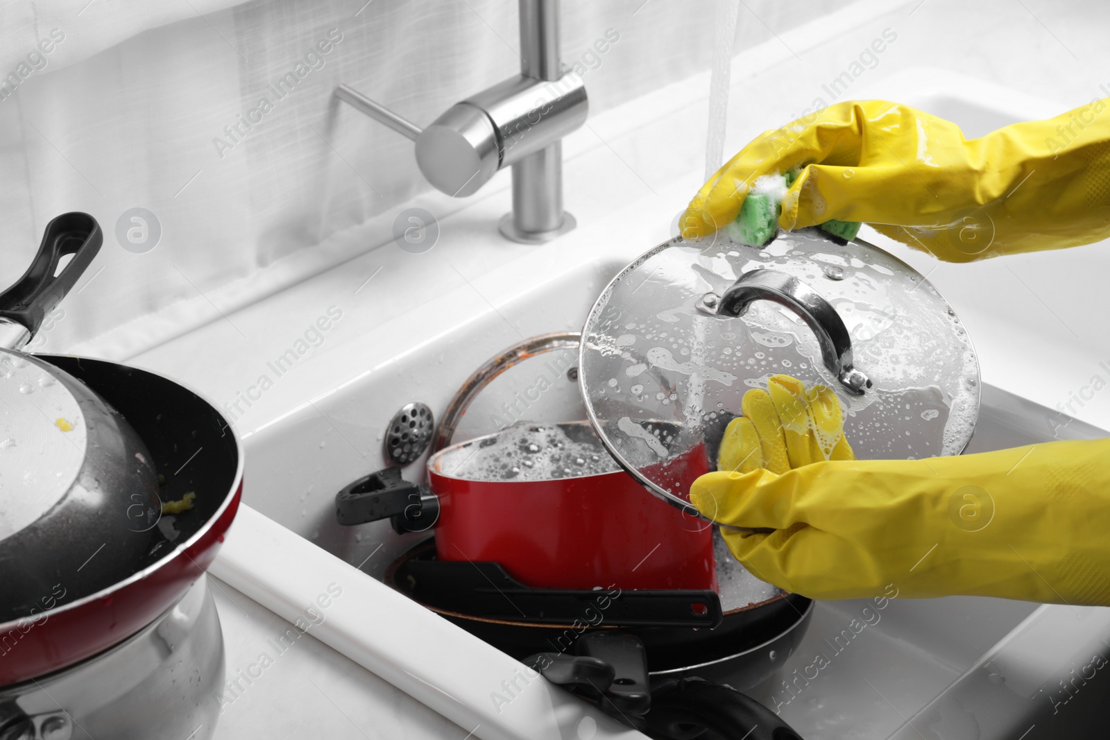 Photo of Woman washing glass lid in kitchen sink, closeup