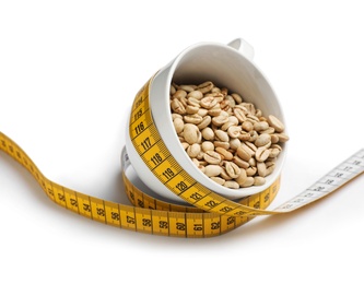 Photo of Cup with green coffee beans and measuring tape on white background