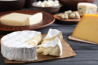 Photo of Clay dishware with fresh dairy products, focus on cheese, closeup