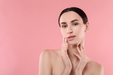 Portrait of beautiful young woman on pink background. Space for text