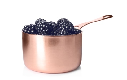 Photo of Saucepan with ripe blackberries on white background