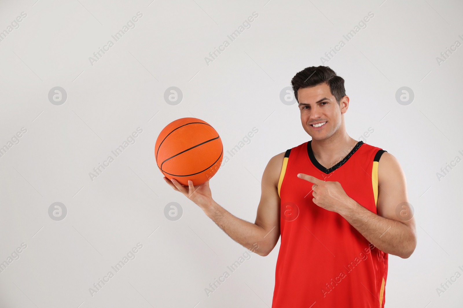 Photo of Basketball player with ball on grey background. Space for text