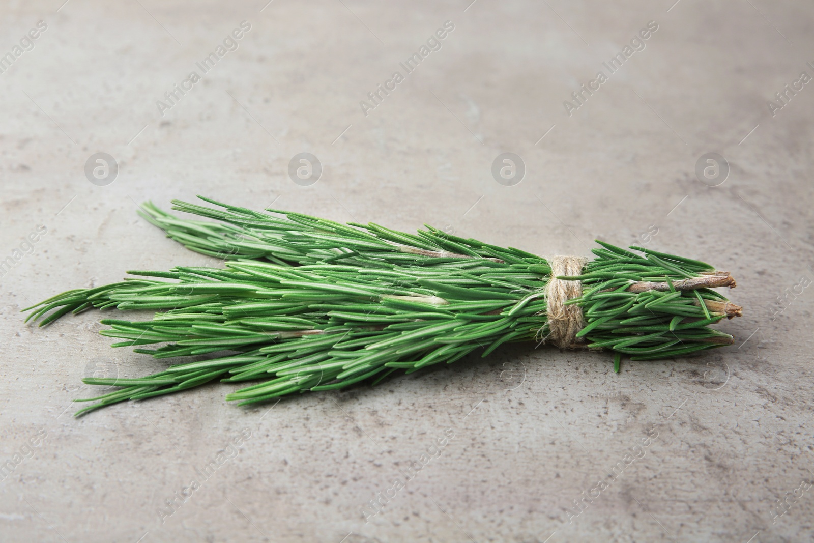 Photo of Bundle of fresh rosemary on grey background