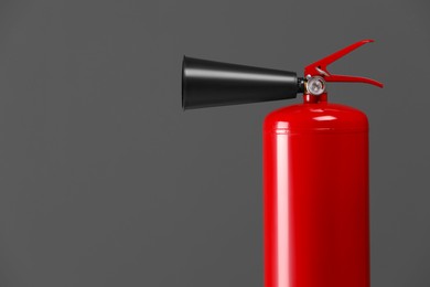 Fire extinguisher on grey background, closeup with space for text