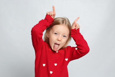 Photo of Portrait of cute funny little girl on light grey background
