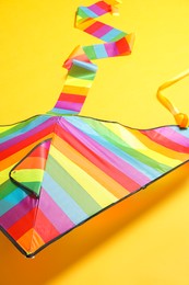 Photo of Beautiful bright rainbow kite on yellow background