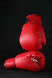 Photo of Red boxing gloves on black marble table. Competition concept