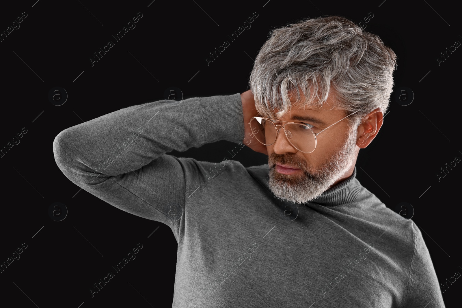 Photo of Portrait of confident man with beautiful hairstyle on black background