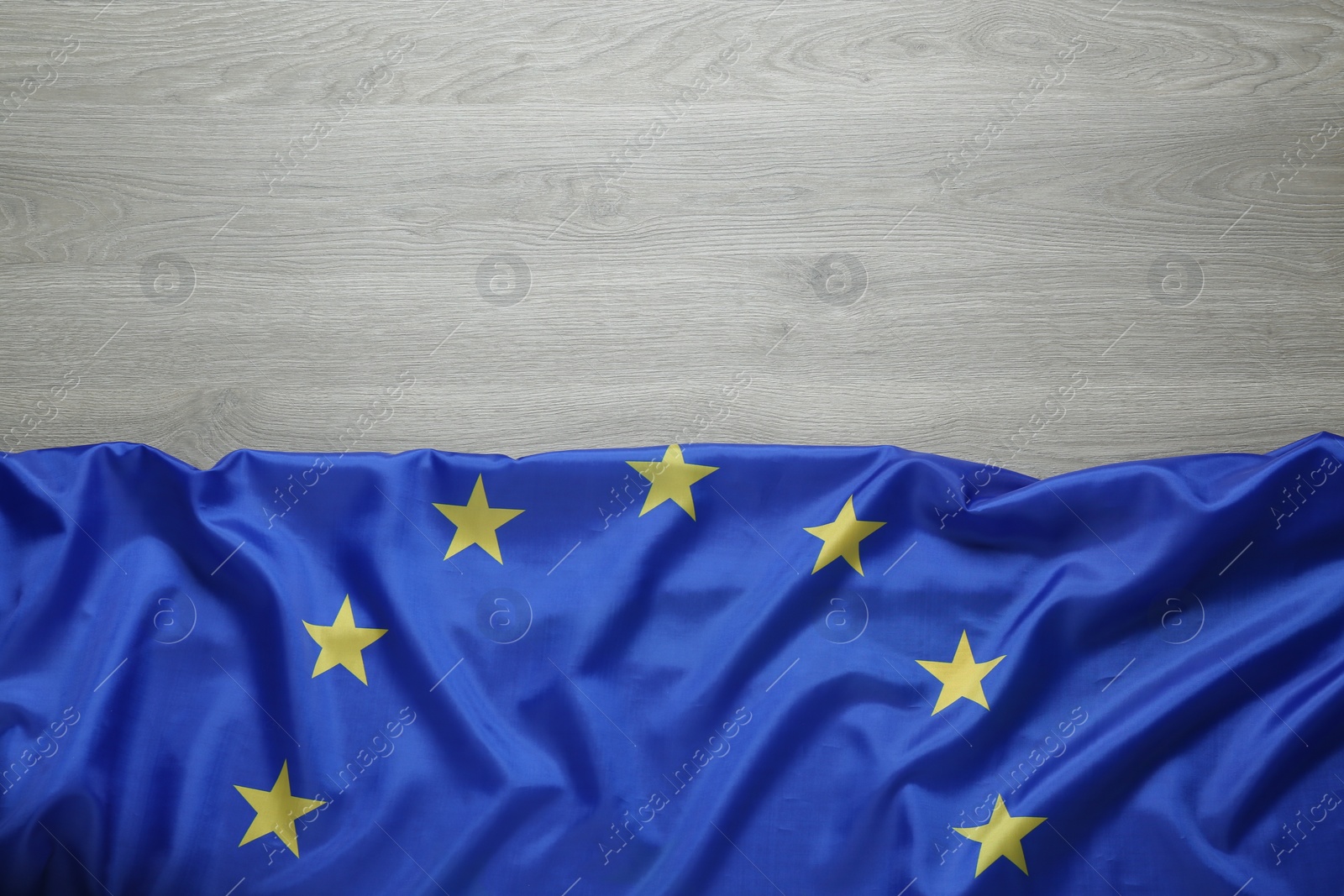 Photo of Flag of European Union on wooden background, top view. Space for text