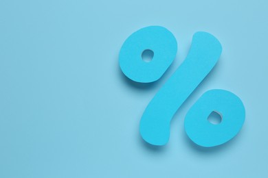 Photo of Percent sign on turquoise background, flat lay. Space for text