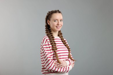 Photo of Woman with braided hair on grey background