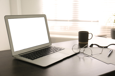 Photo of Modern laptop on office table. Stylish workplace