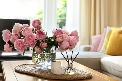 Beautiful pink peonies in vase on table at home, space for text. Interior design