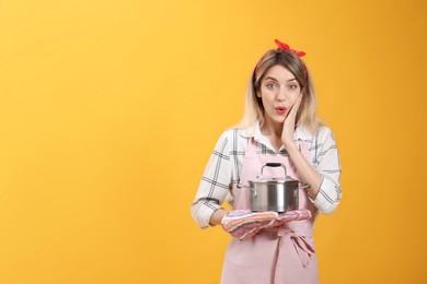 Young housewife with pot on yellow background. Space for text