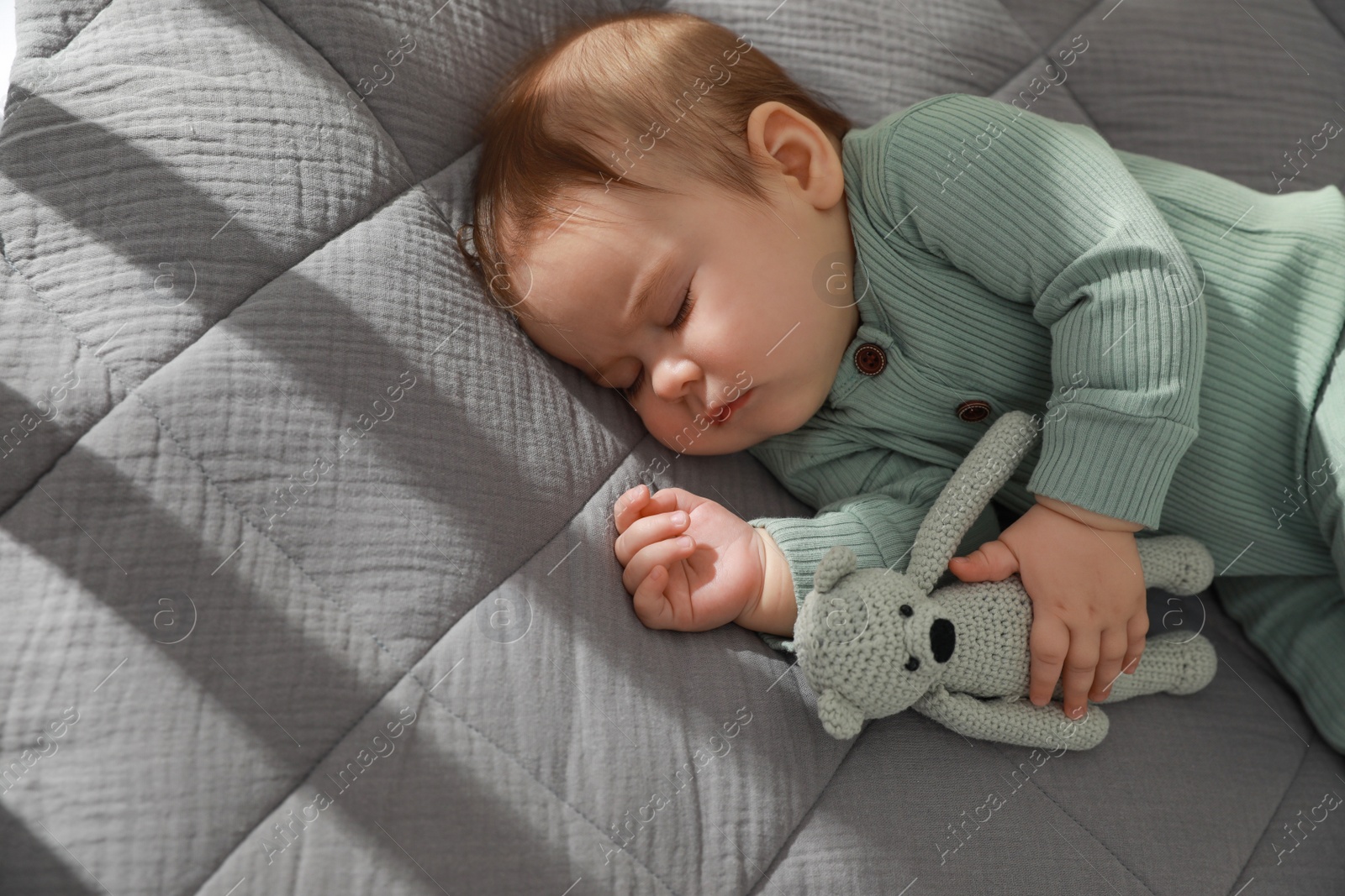 Photo of Cute little baby sleeping on bed, above view. Space for text