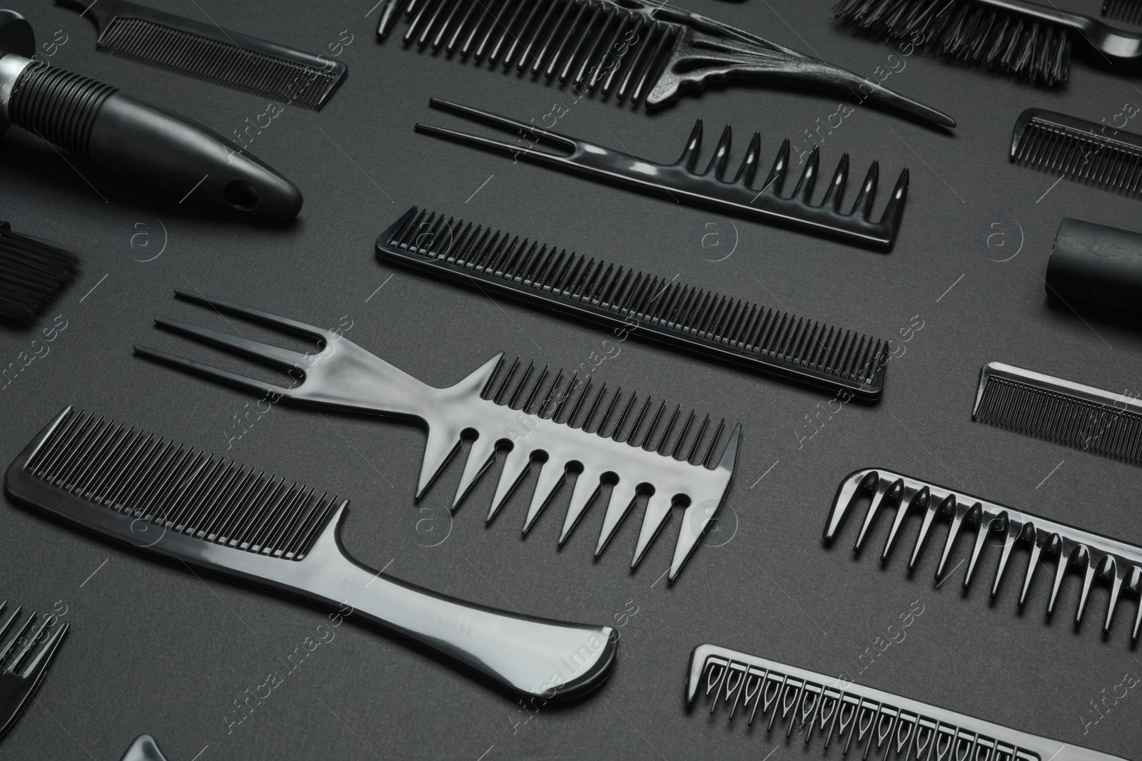 Photo of Composition with modern hair combs on black background