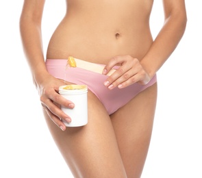 Photo of Young woman waxing bikini area on white background