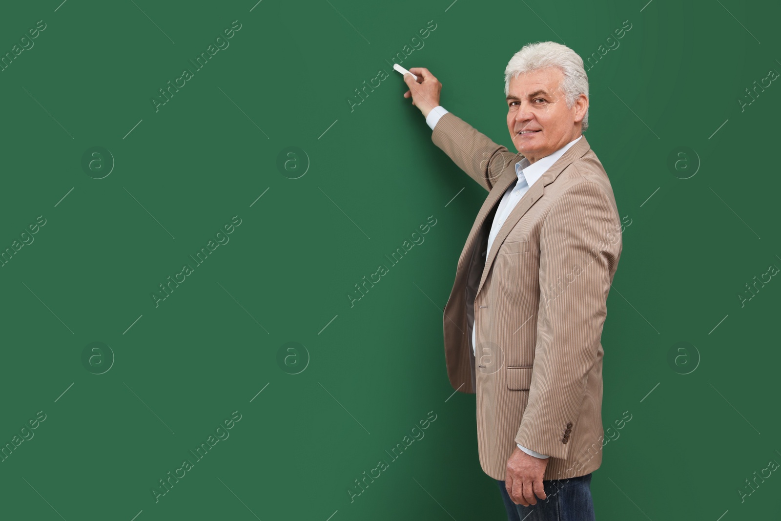 Photo of Portrait of senior teacher with chalk at green board, space for text