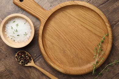 Photo of Cutting board and different spices on wooden table, flat lay