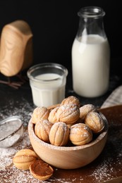 Photo of Homemade walnut shaped cookies with boiled condensed milk on black table, space for text