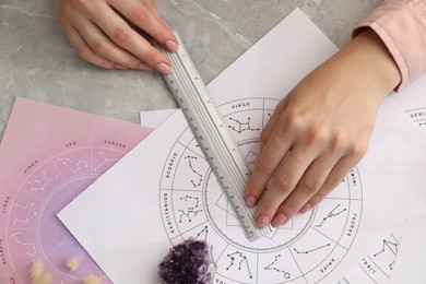 Photo of Astrologer using zodiac wheel for fate forecast at table, top view. Fortune telling