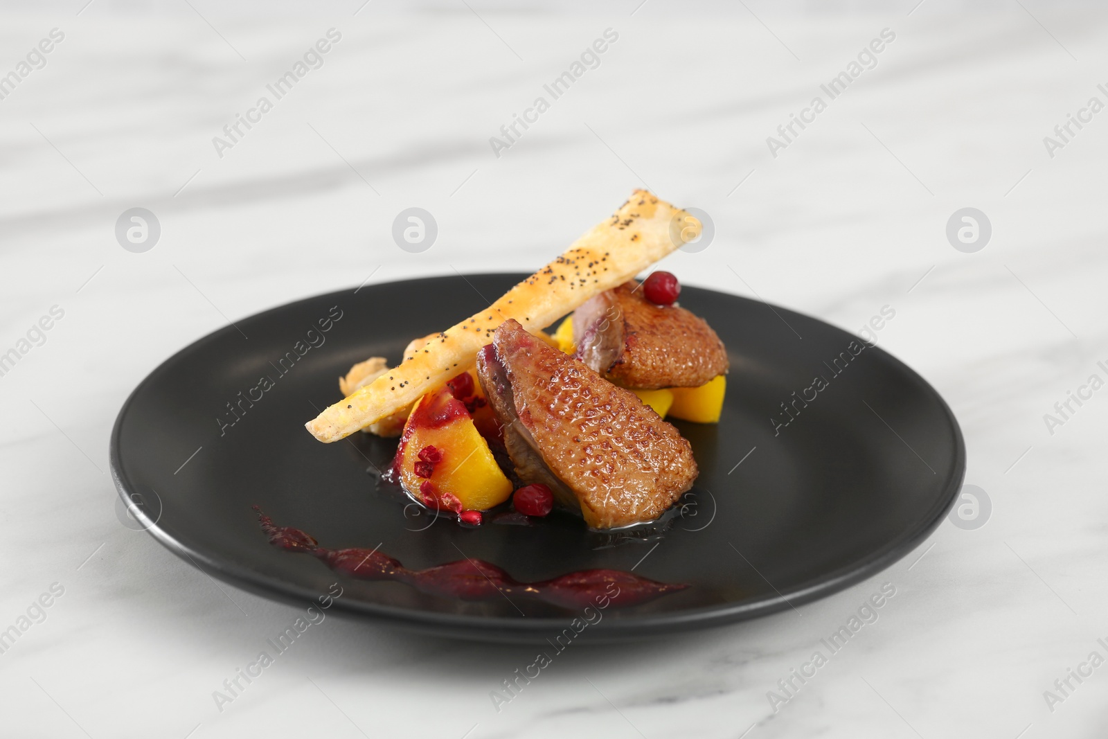 Photo of Delicious dish with meat, potato, sauce and crispy bread on marble table, closeup
