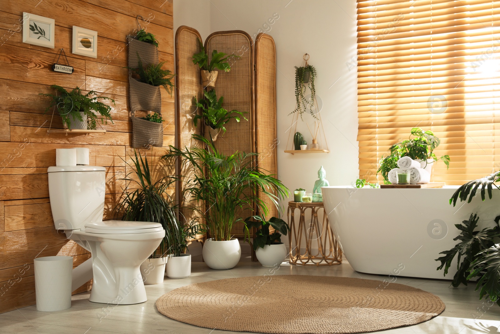 Photo of Stylish bathroom interior with toilet bowl and green plants