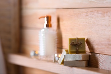 Photo of Soap bars and toiletries on wooden shelf. Space for text