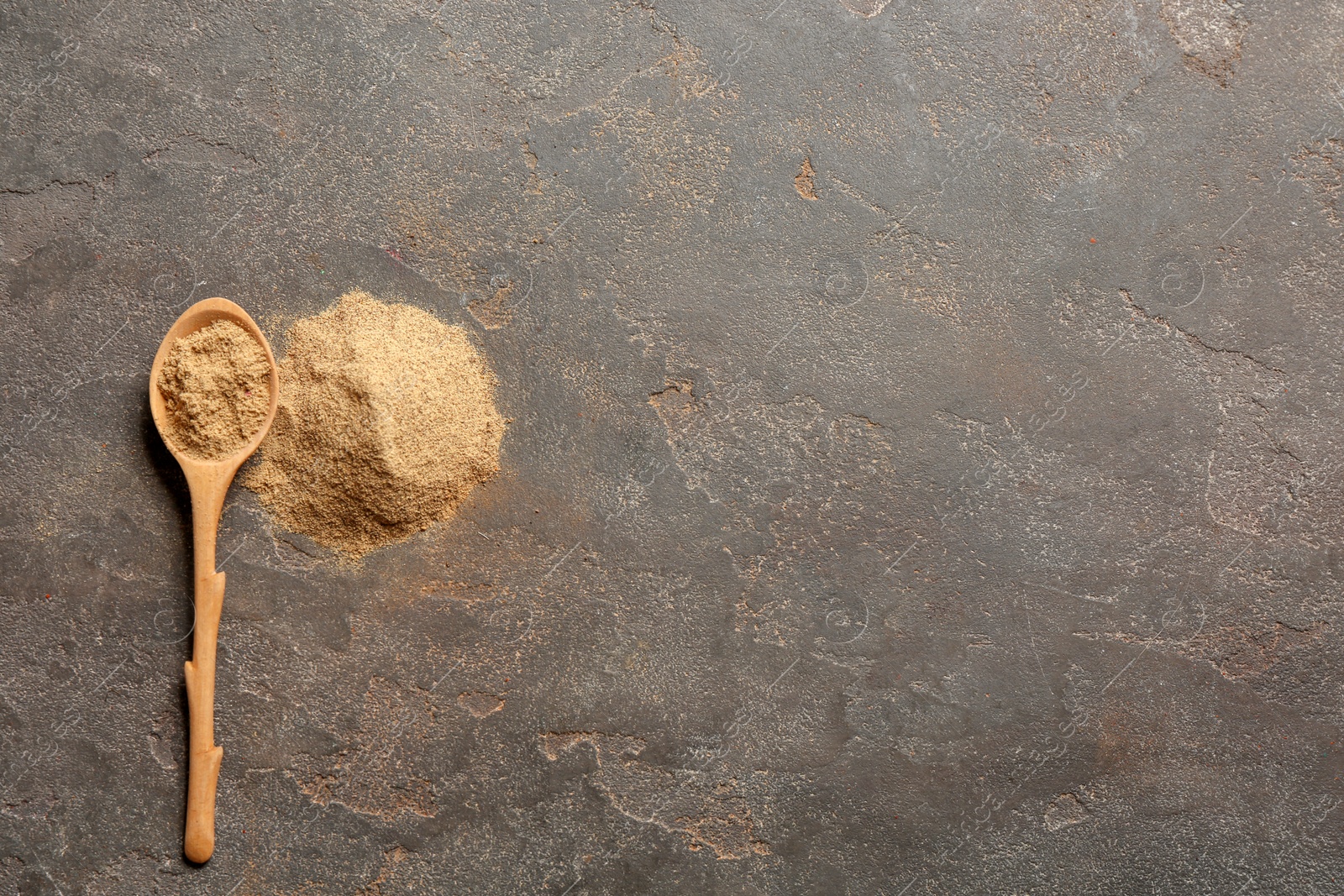 Photo of Spoon and powdered pepper on gray background, top view with space for text