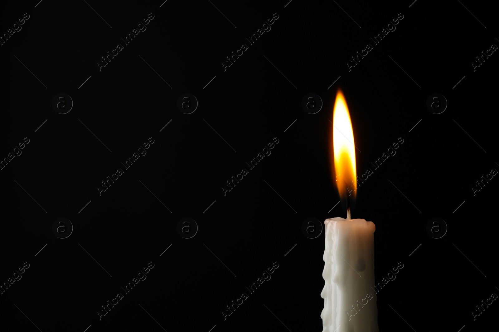 Photo of Burning candle on dark background, space for text. Symbol of sorrow