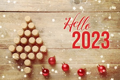 Hello 2023. Christmas tree made of wine corks and baubles on wooden table, flat lay