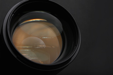 Modern camera lens on black background, closeup