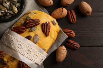 Photo of Delicious pumpkin bread with pecan nuts on wooden table, flat lay