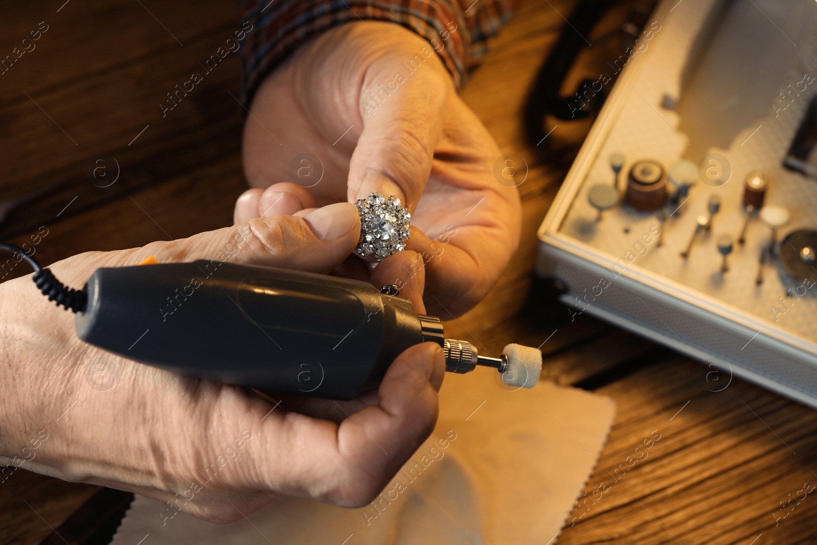 Photo of Professional jeweler working with gemstones at wooden table, above view