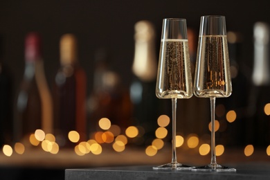 Glasses of champagne on table against blurred background. Space for text