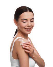 Young woman applying body cream onto her shoulder against white background