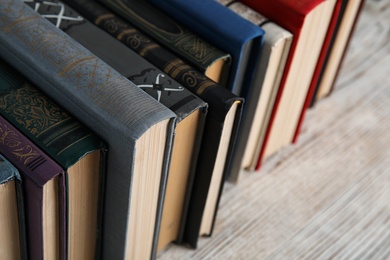 Stack of hardcover books on wooden table, closeup