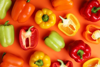 Photo of Flat lay composition with ripe bell peppers on orange background