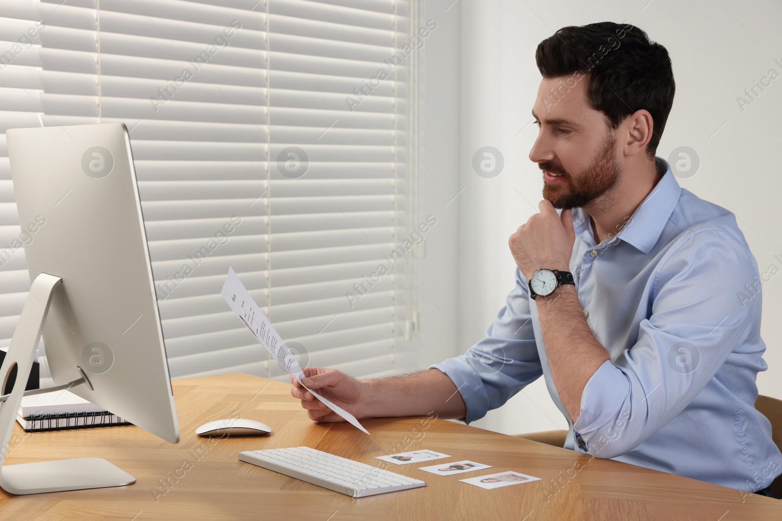 Photo of Human resources manager reading applicant's resume in office