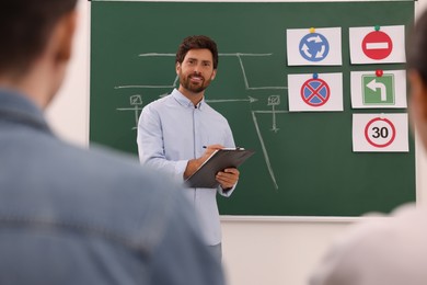 Photo of Teacher giving lesson to audience in driving school