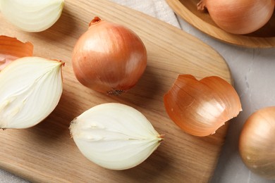 Photo of Whole and cut onions on table, flat lay