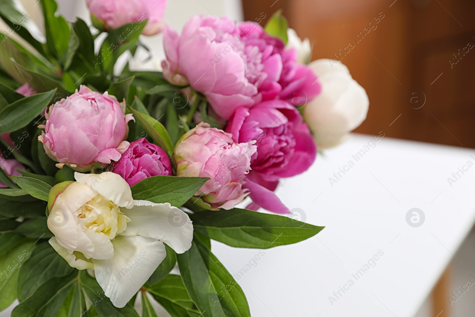 Photo of Bouquet of beautiful peonies on table in room, closeup. Space for text