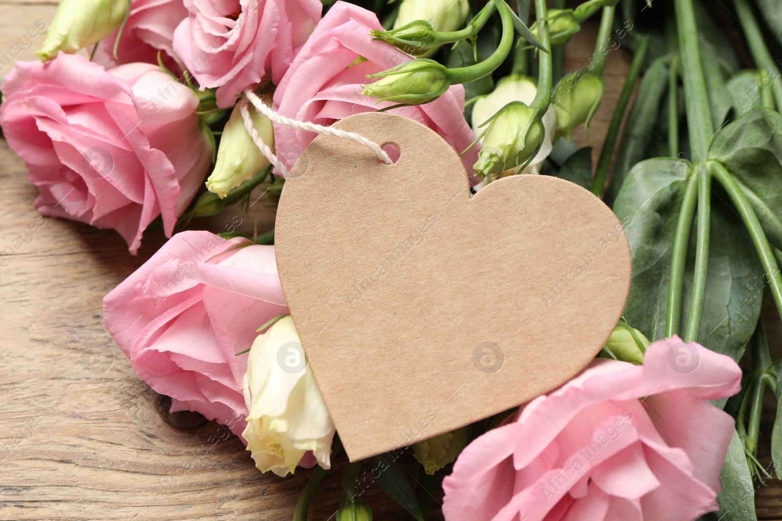 Photo of Happy Mother's Day. Beautiful flowers and blank heart shaped card on wooden table, closeup