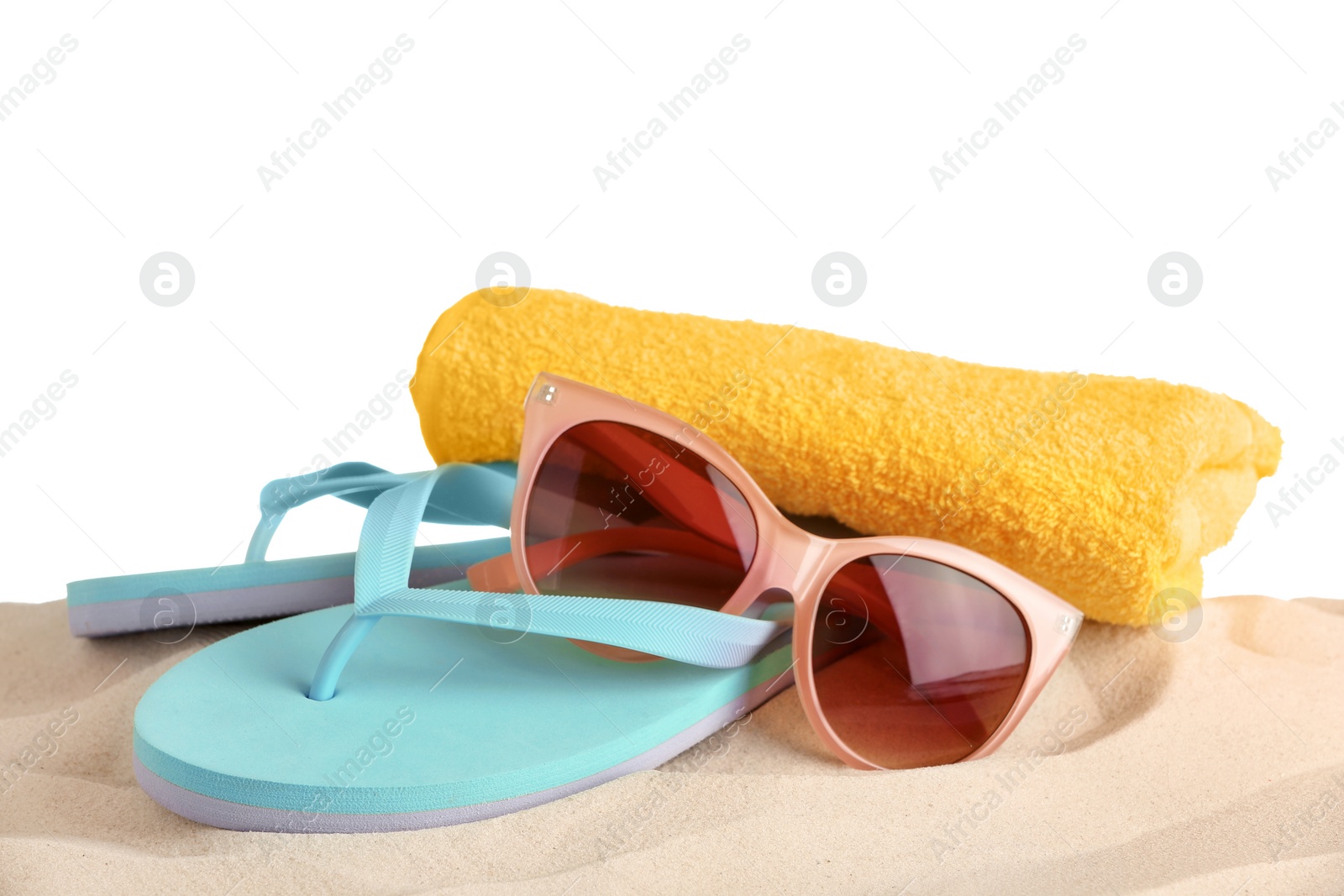 Photo of Beach accessories on sand against white background