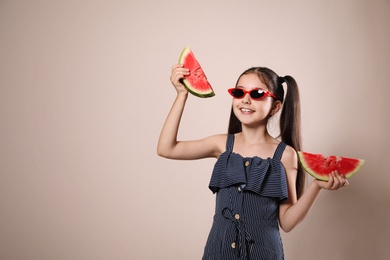 Cute little girl with watermelon on beige background. Space for text